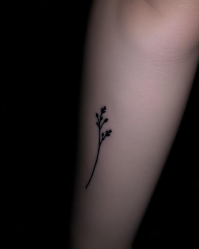 Fine line botanical stem tattoo on inner forearm